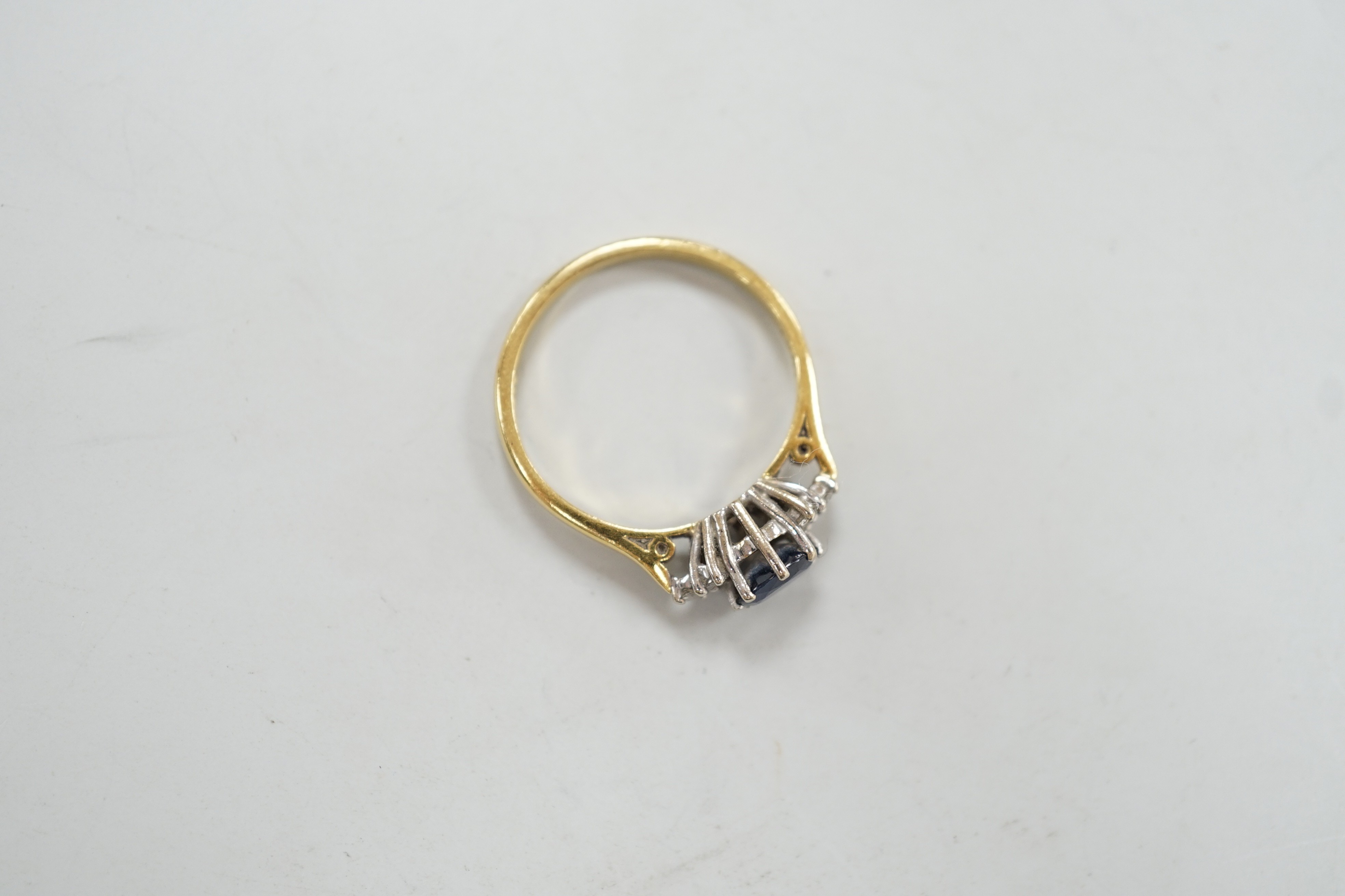 A modern 18ct gold, single stone sapphire and six stone diamond chip set ring, size O/P, gross weight 3.1 grams.